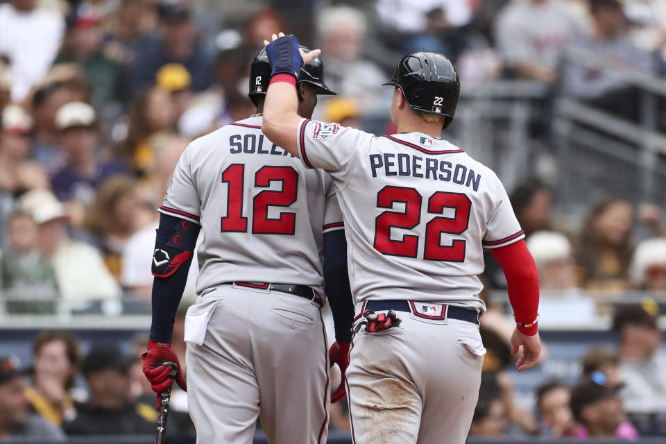 Atlanta Braves' Joc Pederson (22) celebrates with Jorge Soler (12) after scoring on a double by Orlando Arcia against the San Diego Padres in the sixth inning of a baseball game Sunday, Sept. 26, 2021, in San Diego. (AP Photo/Derrick Tuskan)