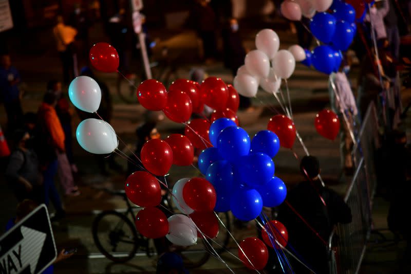 Balloons blow in the wind front of the remaining activists demonstrating across the street from where votes are being counted in Philadelphia