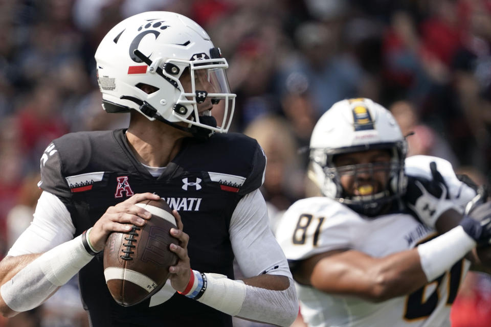 Cincinnati quarterback Desmond Ridder, center, drops back for a pass during the first half of an NCAA college football game against Murray State, Saturday, Sept. 11, 2021, in Cincinnati. (AP Photo/Jeff Dean)