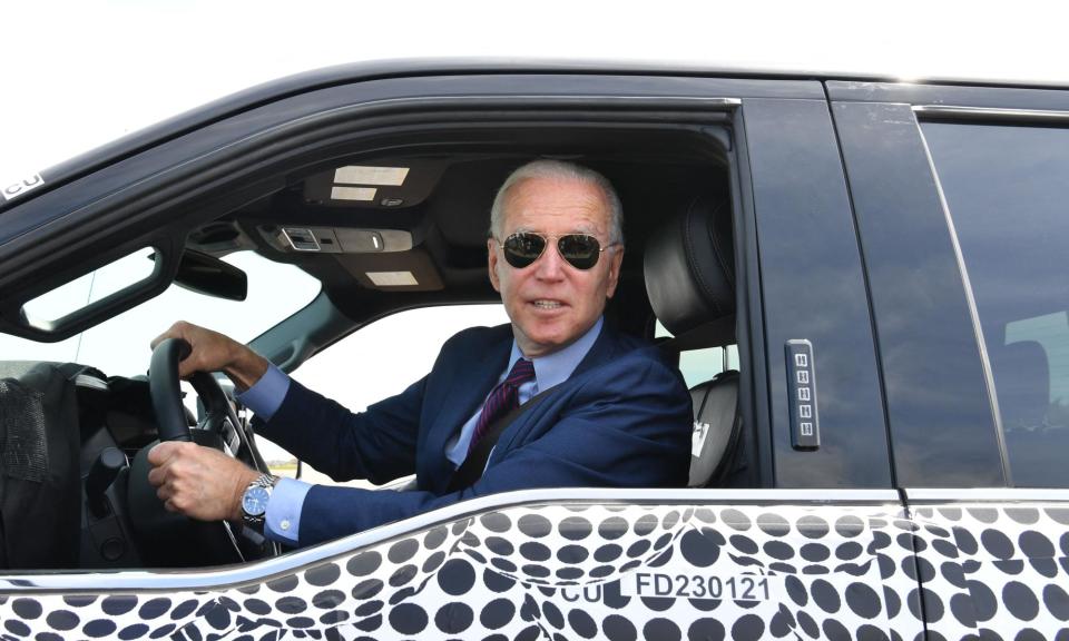 <span>Joe Biden drives a Ford F-150 truck in Dearborn, Michigan, in May 2021.</span><span>Photograph: Nicholas Kamm/AFP/Getty Images</span>