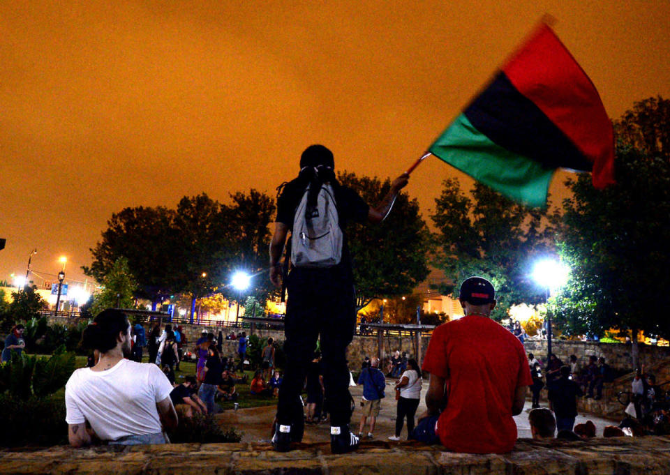 <p>A protester waves a flag as protesters congregate in a park area along the Little Sugar Creek Greenway Sunday, Sept. 25, 2016 in Charlotte, N.C. (Jeff Siner/Charlotte Observer/TNS via Getty Images)</p>