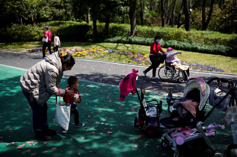 A woman takes care of a little boy in a park in Shanghai