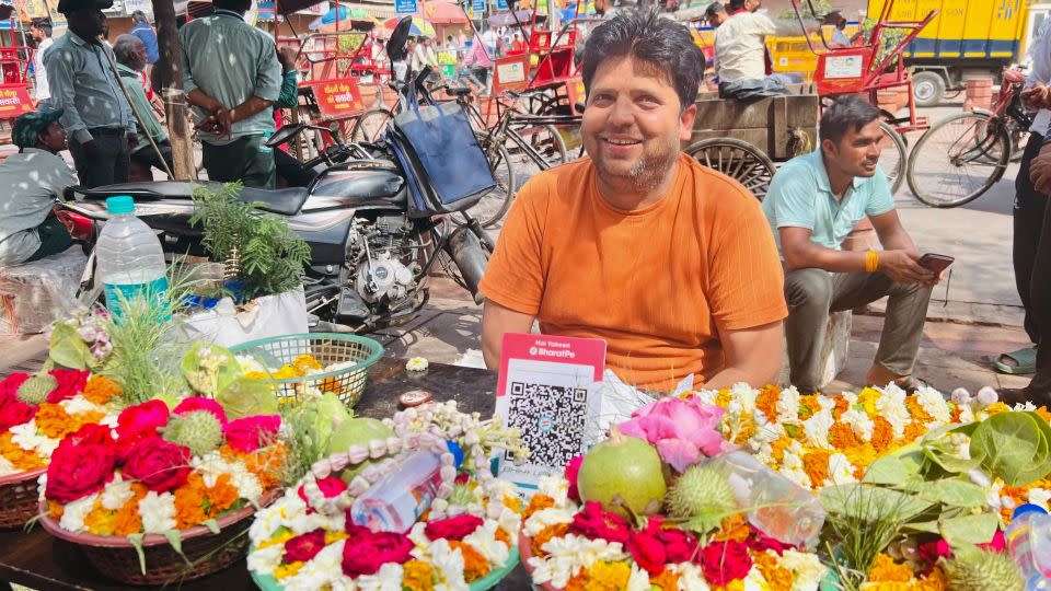 Flower seller Kapil Sharma offers a QR code for customers. - Sania Farooqui/CNN