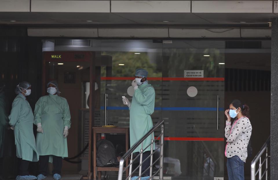 Health workers stand outside the entrance of Sir Ganga Ram Hospital in New Delhi, India, Friday, April 23, 2021. The Press Trust of India reported 25 COVID-19 patients died at Sir Ganga Ram Hospital in the past 24 hours and the lives of another 60 were at risk amid a serious oxygen supply crisis. The news agency quoted unnamed officials as saying “low pressure oxygen” could be the likely cause for their deaths. However, Ajoy Sehgal, a hospital spokesperson, would not comment on whether the 25 patients died from a lack of oxygen. (AP Photo)