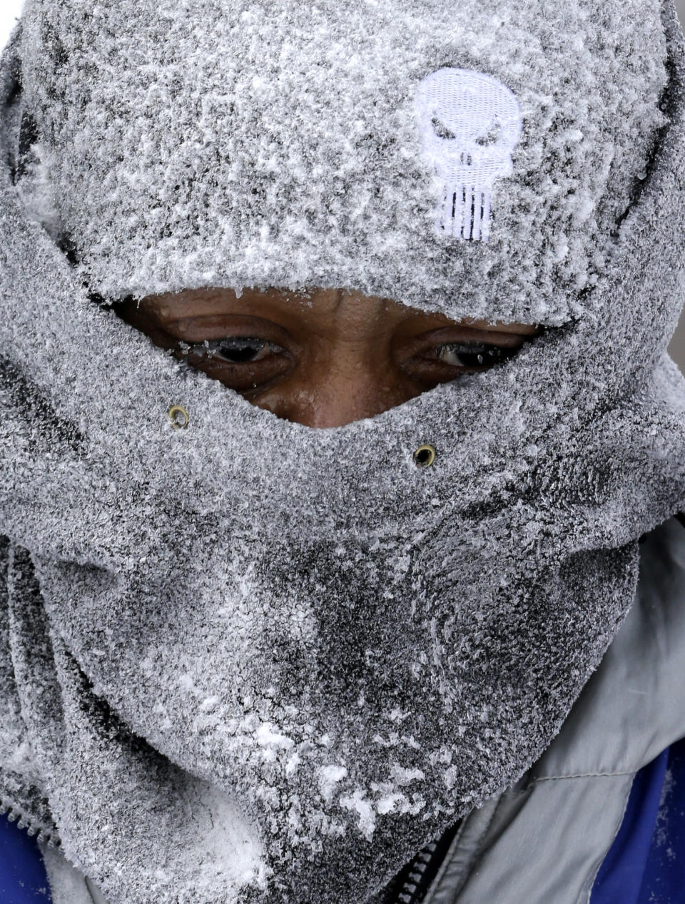 Hank Wade is bundled up as he clears snow from a sidewalk Monday, Jan. 6, 2014, in Lyndhurst, Ohio. Forecasters say low temperatures around zero, with possible wind chill factors of 40 below zero, are possible through Wednesday. The entire state was under a rare wind chill warning, which means frostbite could affect exposed skin within 10 minutes outside.(AP Photo/Tony Dejak)