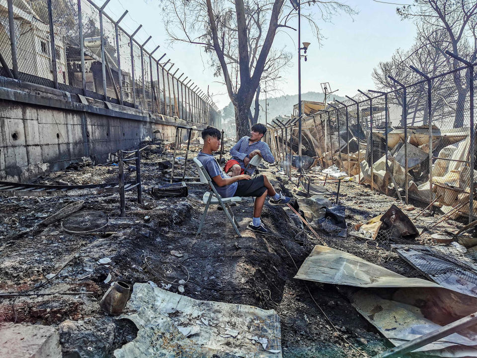 Image: Migrants sit inside the burnt Moria Camp on the Greek island of Lesbos on Sept. 9, 2020, after a major fire. (Anthi Pazianou / AFP - Getty Images)