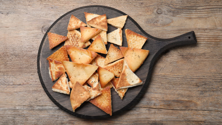 Pita chips on chopping board