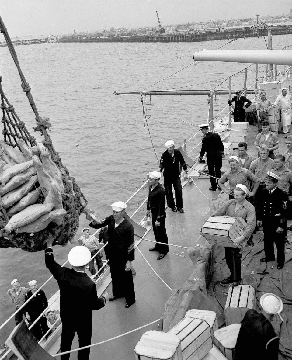 FILE - Provisioning of the USS Indianapolis goes forward in preparation for departure from San Pedro, Calif., on April 14, 1937. The U.S. Navy on Friday, May 26, 2022, said it has changed the status of 13 sailors who were lost when Japanese torpedoes sank the USS Indianapolis July 30, 1945. There were only 316 survivors among the ship's crew of 1,195 sailors. About 300 went down with the ship and about 900 men were set adrift. (AP Photo/DBJ, File)