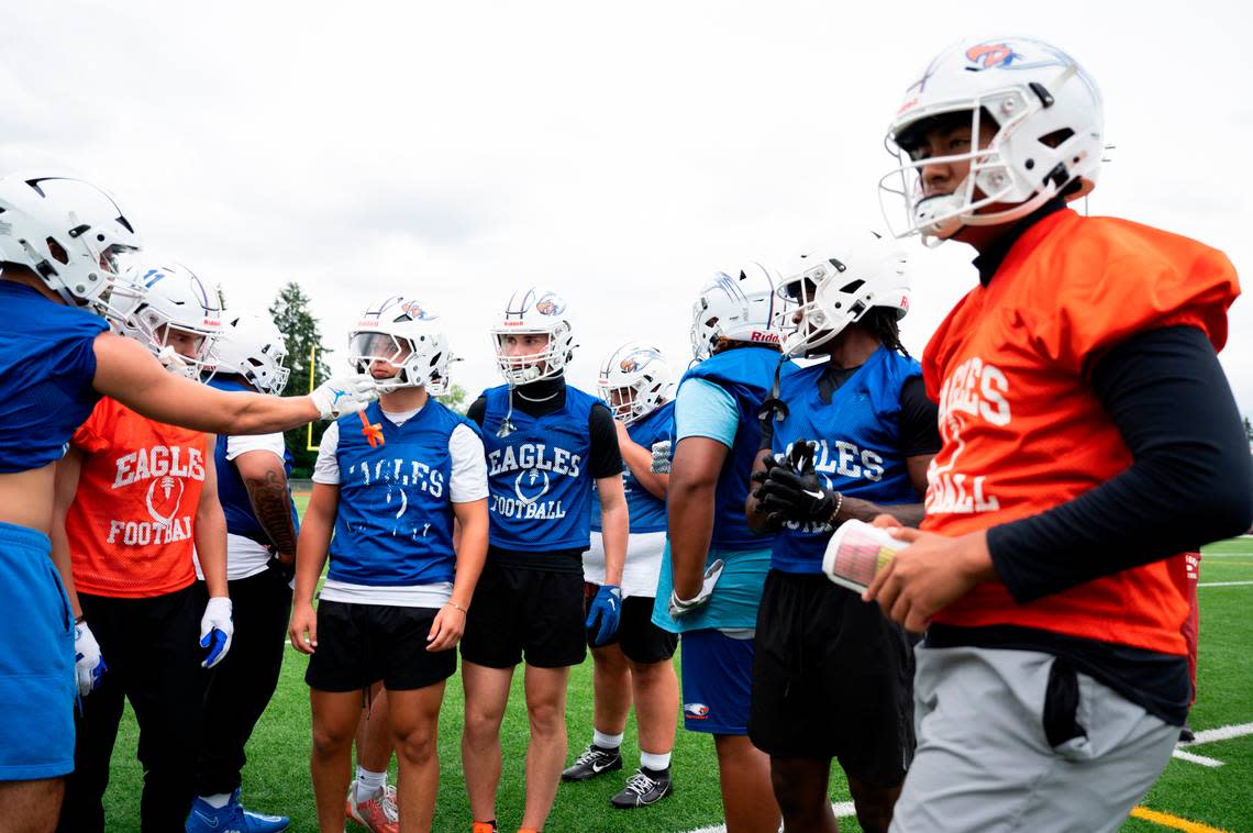 Players huddle before running a play during a football practice at Graham-Kapowsin High School, on Thursday, Aug. 22, 2024, in Graham, Wash.