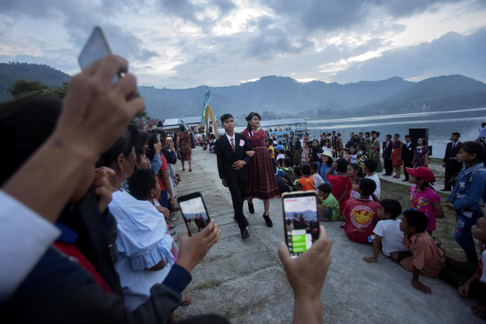 In this Friday, Oct. 25, 2019, photo, participants perform during a fashion show held as a part of Toba Pig and Pork Festival, in Muara, North Sumatra, Indonesia. Christian residents in Muslim-majority Indonesia's remote Lake Toba region have launched a new festival celebrating pigs that they say is a response to efforts to promote halal tourism in the area. The festival features competitions in barbecuing, pig calling and pig catching as well as live music and other entertainment that organizers say are parts of the culture of the community that lives in the area. (AP Photo/Binsar Bakkara)