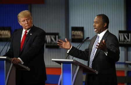 Republican U.S. presidential candidate and businessman Donald Trump (L) listens as Dr. Ben Carson (R) speaks during the debate held by Fox Business Network for the top 2016 U.S. Republican presidential candidates in Milwaukee, Wisconsin, November 10, 2015. REUTERS/Jim Young