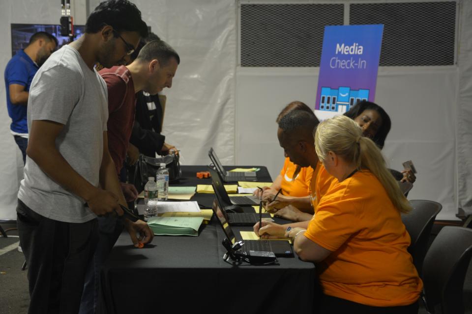 Applicants looking for warehouse associate positions write down their names on a yellow paper. They also get tickets with numbers and wait to be called for a tour in the warehouse.