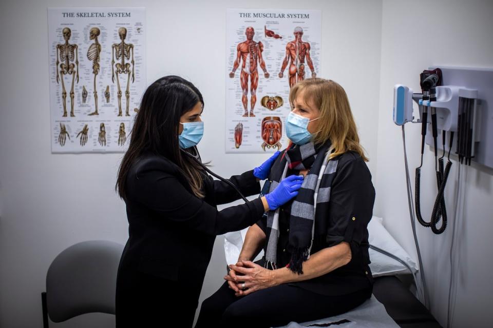 A nurse practitioner meets with her patient at the Axis Primary Care Clinic in Surrey, B.C. in 2021. Alberta is putting a compensation model in place that will allow NP-led clinics as soon as January. (Ben Nelms/CBC - image credit)