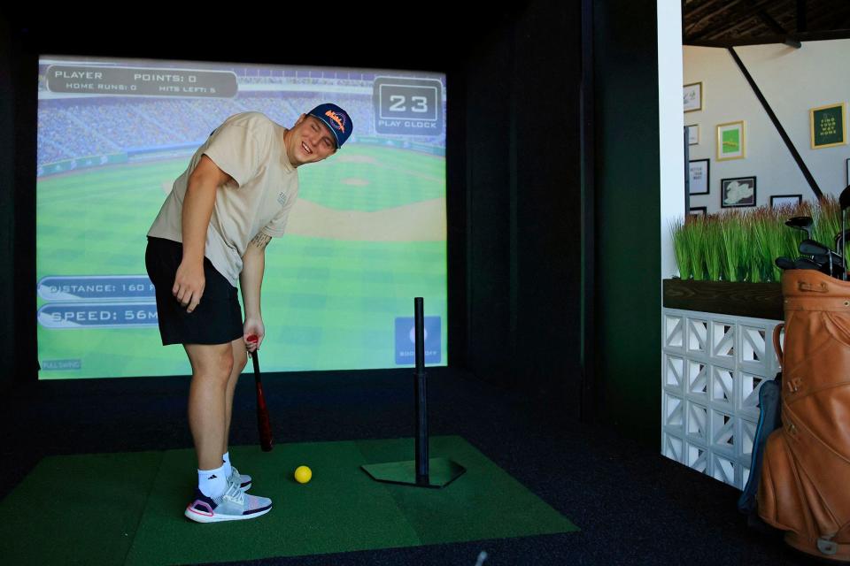 Caleb Brachbill of Chicago laughs while playing baseball on one of the four sports simulators at the recently opened Fore Score Golf Tavern on historic San Marco Square in Jacksonville.