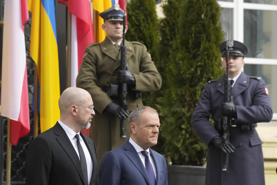 Ukrainian Prime Minister Denys Shmyhal, left, and his Polish counterpart, Prime Minister Donald Tusk, center, review troops during a welcoming ceremony ahead of their talks in Warsaw, Poland, Thursday March 28, 2024. (AP Photo/Czarek Sokolowski)