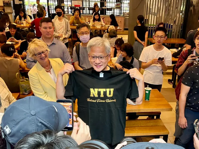 ▲黃仁勳拿到台大校長陳文章致贈的NTU T-SHIRT，十分開心的拿出來比量。