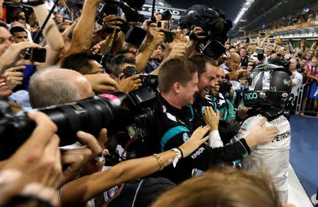 Formula One - F1 - Abu Dhabi Grand Prix - Yas Marina Circuit, Abu Dhabi, United Arab Emirates - 27/11/2016 - Mercedes' Formula One driver Nico Rosberg (R) of Germany celebrates after winning the Formula One world championship. REUTERS/Hamad I Mohammed