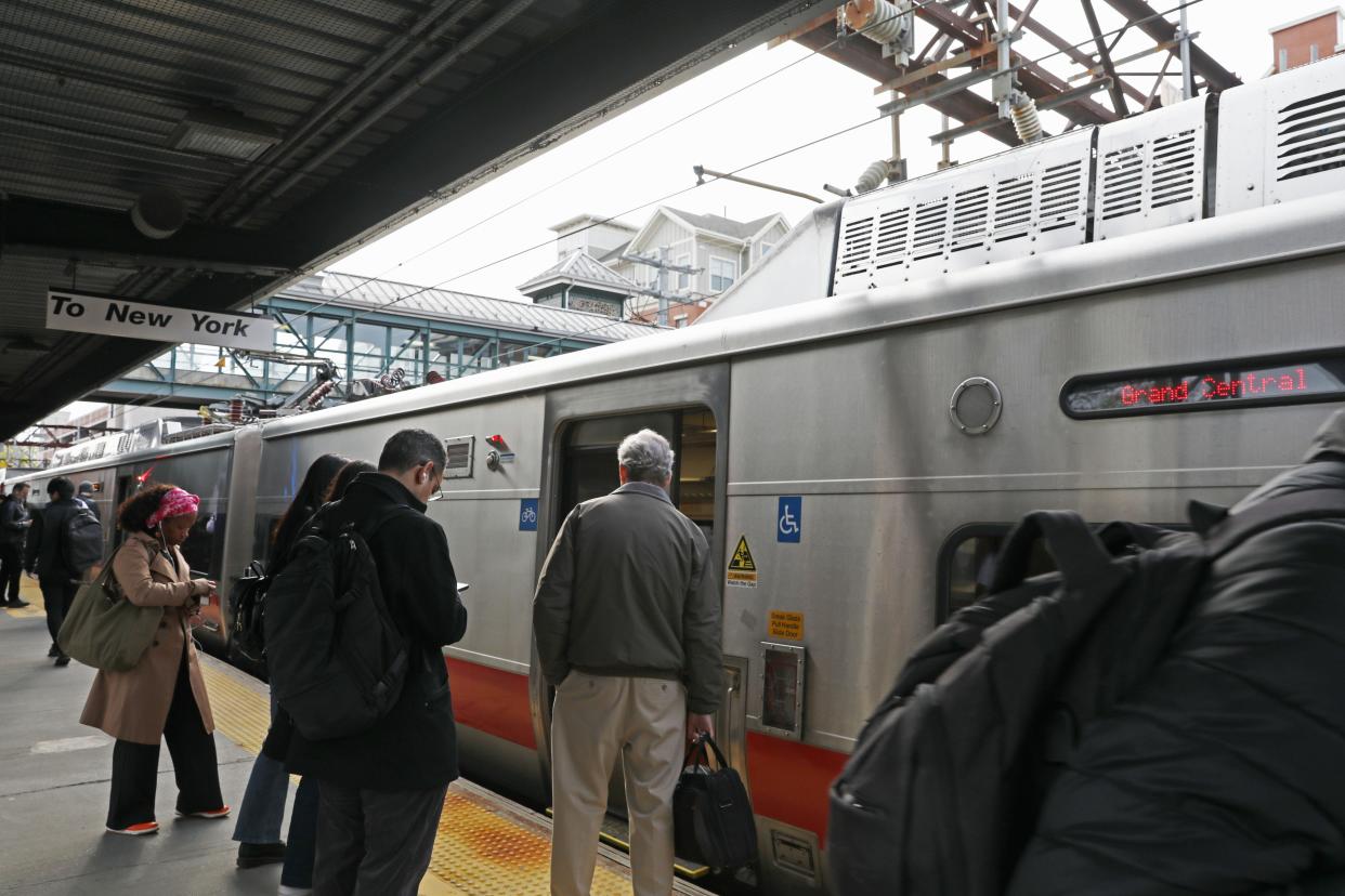 Commuters board a New York City bound train at the Harrison Metro-North station April 19, 2024 in Harrison. The Metro-North led transit oriented development project, the Avalon Harrison, which has 143 apartment units and was completed in 2023, is seen behind the tstation.