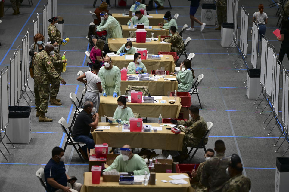 Health workers get vaccinated for COVID-19 at the Pedrin Zorrilla Coliseum in San Juan, Puerto Rico, Wednesday, Dec. 30, 2020. (AP Photo/Carlos Giusti)