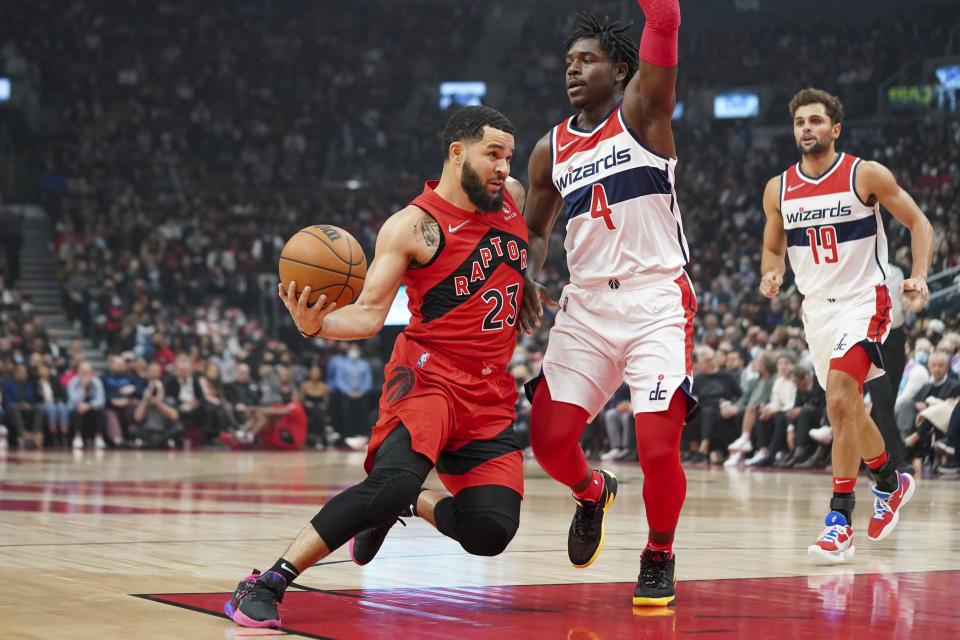 Toronto Raptors guard Fred VanVleet (23) drives past Washington Wizards guard Aaron Holiday (4) during the first half of an NBA basketball game Wednesday, Oct. 20, 2021, in Toronto. (Evan Buhler/The Canadian Press via AP)