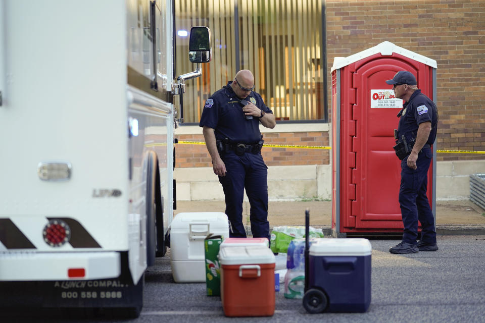 Police officers stand at the scene where an apartment building partially collapsed two days earlier, Tuesday, May 30, 2023, in Davenport, Iowa. Five residents of the six-story apartment building remained unaccounted for and authorities feared at least two of them might be stuck inside rubble that was too dangerous to search. (AP Photo/Erin Hooley)