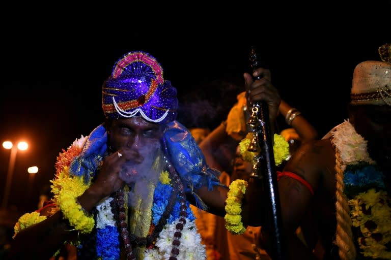 A Malaysian Hindu devotee smokes a cigar and dances in a trance outside the Batu caves temple during the Thaipusam festival in Kuala Lumpur