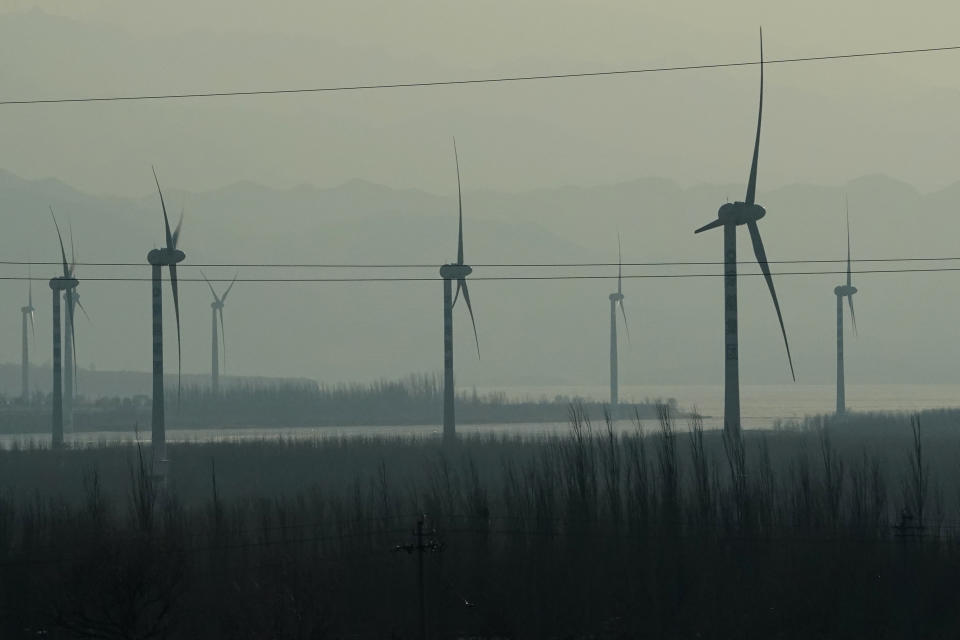 Windmills are seen from a high speed train traveling from Beijing to neighboring Zhangjiakou in northwestern China's Hebei province on Dec. 15, 2020. Expectations are high that the 14th five-year plan will align domestic policies with international pledges on climate change. Chinese President Xi Jinping made a surprise pledge at a United Nations meeting in September that China would go carbon neutral by 2060. (AP Photo/Ng Han Guan)