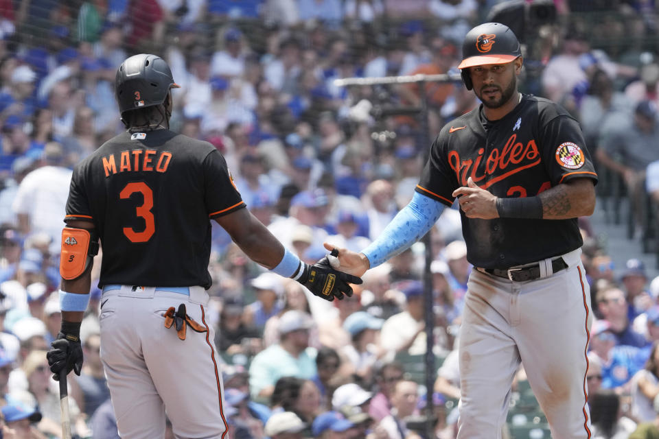 Baltimore Orioles' Aaron Hicks, right, celebrates. with Jorge Mateo (3) after scoring on a one-run single by Adam Frazier during the sixth inning of a baseball game against the Chicago Cubs in Chicago, Sunday, June 18, 2023. (AP Photo/Nam Y. Huh)