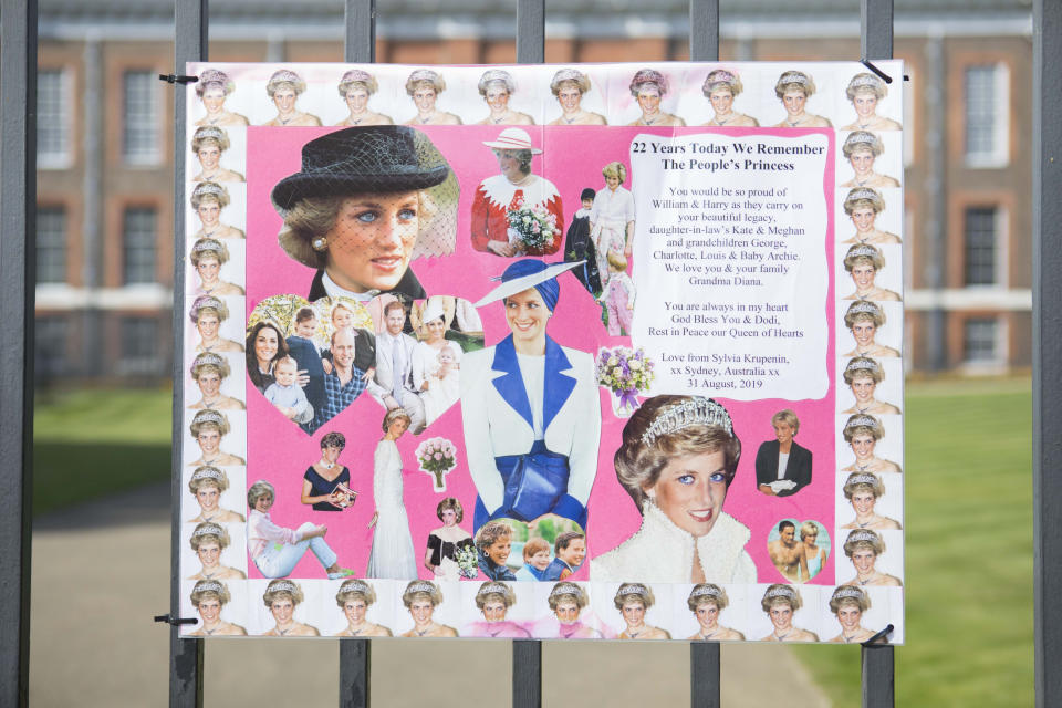 A pink poster with images and memories of Princess Diana sits on the gates of Kensington Palace on August 31 2019