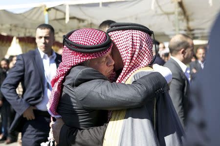 Jordan's King Abdullah (L) offers his condolences to Safi al-Kasaesbeh, the father of Jordanian pilot Muath al-Kasaesbeh, at the headquarters of the family's clan in the city of Karak February 5, 2015.REUTERS/Petra News Agency