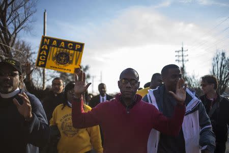 Cornell William Brooks, the President and CEO of the National Association for the Advancement of Colored People (NAACP), raises his hands while marching through Ferguson, Missouri November 29, 2014. REUTERS/Adrees Latif