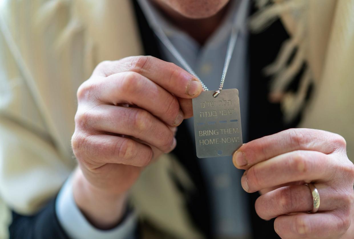 Rabbi Shalom Kantor of Congregation B'nai Moshe in West Bloomfield holds a necklace he wears that says "Bring them home now" on Monday, April 15, 2024. He purchased the item in Hostage Square in Israel, and it references the Israeli hostages taken by Hamas in October 2023. A group of rabbis, including Kantor, traveled together several weeks ago to Israel for an emotional trip, visiting sites struck by terrorists.