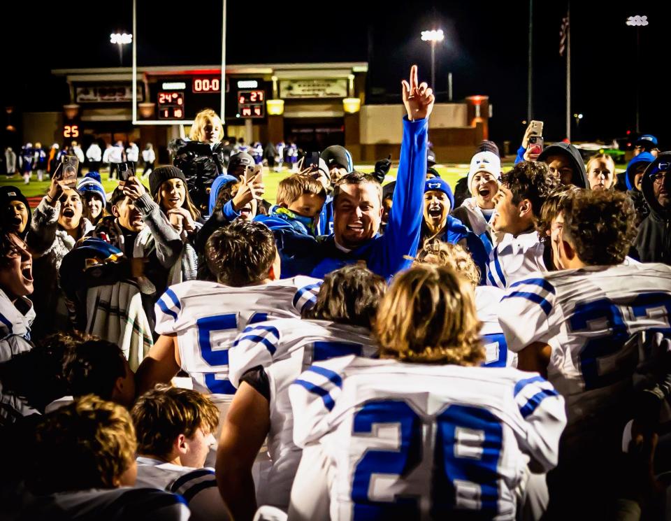 Head coach Trevor Powers celebrates with the Hooker football team.