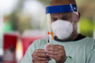 A healthcare worker prepares a dose of the Johnson & Johnson COVID-19 vaccine during a vaccination campaign on the Isla Verde public beach as part of the “Noche de San Juan” festivities, a traditional all-day celebration to mark the birth of St. John the Baptist, in Carolina, Puerto Rico, Wednesday, June 23, 2021. This year COVID-19 vaccines will be available to devotees heading to the beach to celebrate the saint’s June 24th feast day. (AP Photo/Carlos Giusti)