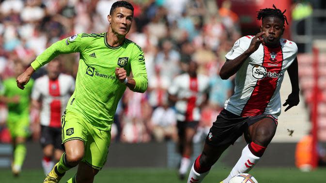 <p>Striker Manchester United Cristiano Ronaldo (kiri) berlari dengan bola dalam pertandingan Liga Inggris antara Southampton dan MU di Stadion St Mary, Sabtu, 27 Agustus 2022. (Adrian DENNIS / AFP)</p>