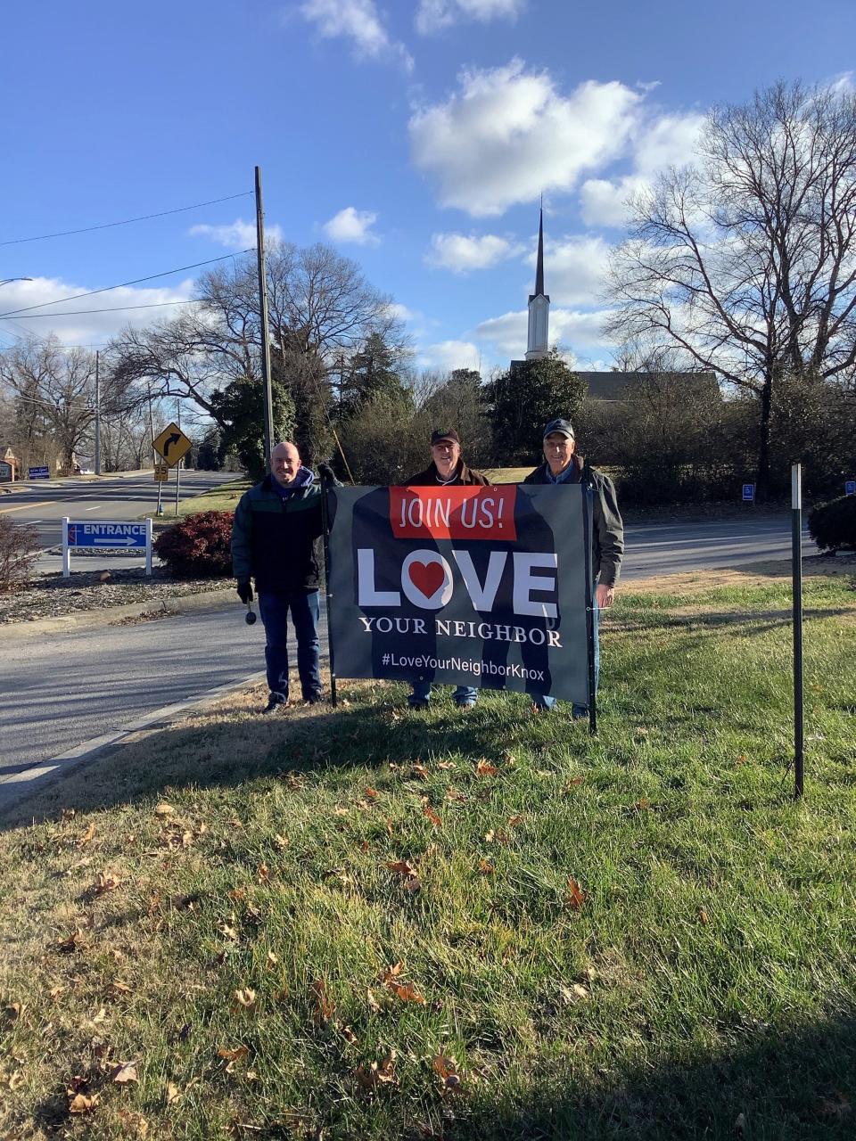 The Rev. Troy Forrester, Dick Hinton, and Joe Benedict, from left, are shown after installing a banner sign in front of First United Methodist Church last year as part of the Love Your Neighbor initiative. The program is designed to encourage houses of worship to push the message of love during this contentious time in American politics and society.