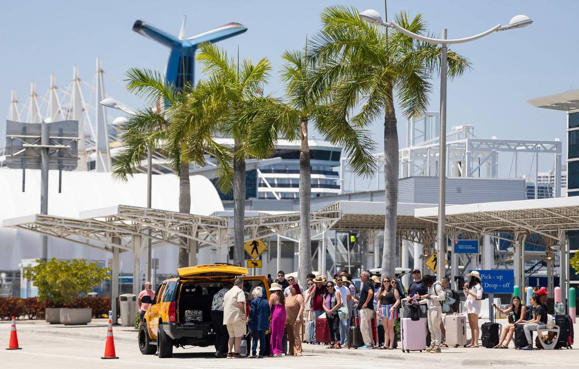 A group of travelers wait for shuttles at PortMiami on Friday, April 12, 2024, in Miami, Fla.