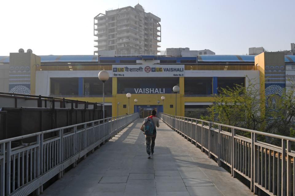A commuter walks in front of closed metro station during a one-day Janata (civil) curfew imposed amid concerns over the spread of the COVID-19 novel coronavirus, in Ghaziabad on the outskirts of New Delhi on March 22, 2020. (Photo by Prakash SINGH / AFP) (Photo by PRAKASH SINGH/AFP via Getty Images)