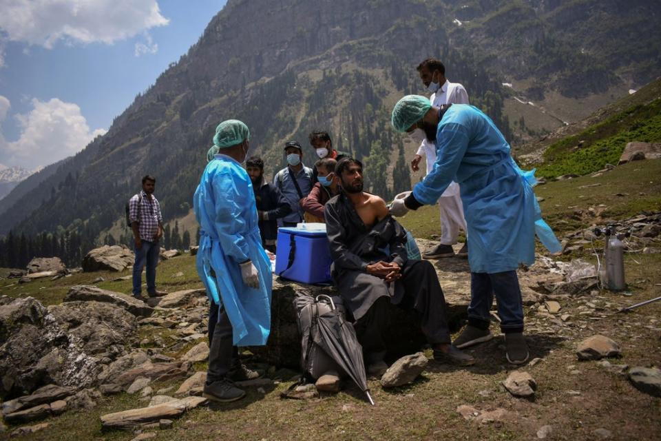 A healthcare worker administers a dose of CoviShield vaccine to a shepherd during a vaccination drive in Lidderwat, in Kashmir's Anantnag district on 10 June 2021 (Reuters/Sanna Irshad)