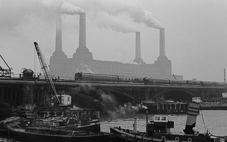 A view across the Thames towards Battersea Power Station, with a train crossing Grosvenor Bridge (aka Victoria Railway Bridge) in the foreground, London, 28th December 1966. (Photo by Chris Morphet/Getty Images)  - Getty