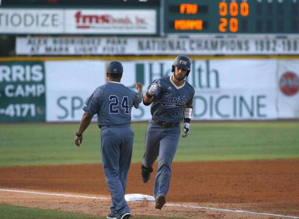 FIU Panthers JC catcher Escarra is congratulated by FIU Panthers head coach Mervyl Melend after hitting a solo home run during the third inning of a NCAA baseball game against the Miami Hurricanes at Alex Rodriguez Park at Mark Light Field on Wed., April 26, 2017 in Coral Gables.