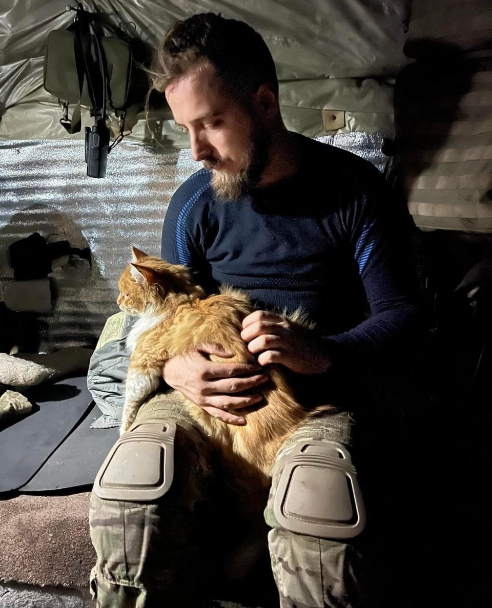 Maksym Kryvtsov with a cat on the front line