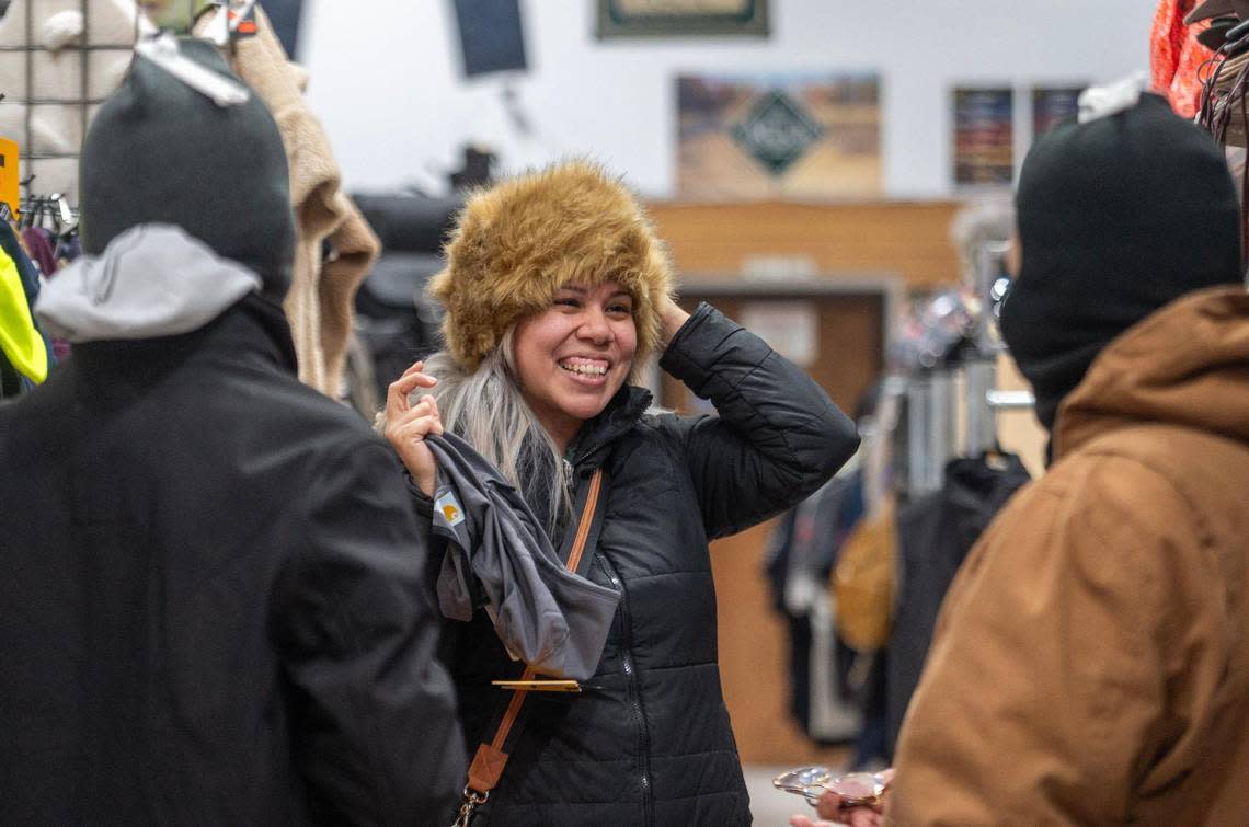 Anabel Calderon tries on a fur hat while shopping at Mickey’s Surplus Store on Thursday in Kansas City, Kansas. Calderon says she will be attending the NFL playoff game between the Kansas City Chiefs and the Miami Dolphins on Saturday at Arrowhead Stadium where the forecast calls for a wind chill as low as minus 35.