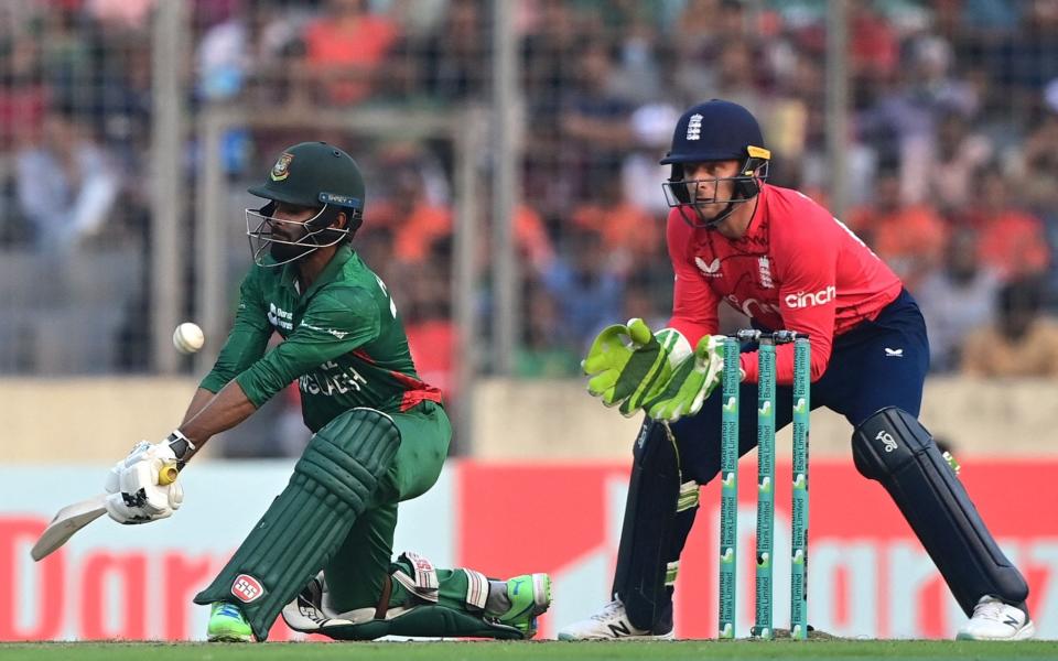 Towhid Hridoy plays a reverse sweep as Jos Buttler watches on - Munir Uz Zaman/AFP