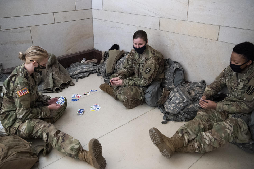 Members of the National Guard play cards in the Capitol Visitors Center as the House of Representatives votes on the impeachment of President Donald Trump. (Caroline Brehman/CQ-Roll Call, Inc via Getty Images)