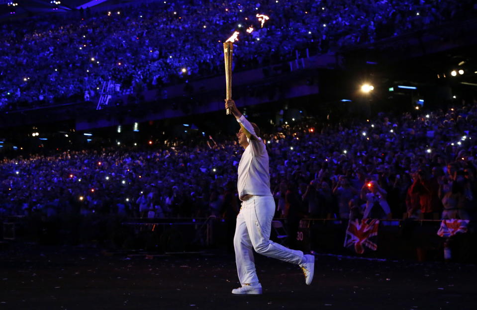 Steve Redgrave enters the Olympic Stadium with the Olympic flame during the Opening Ceremony at the 2012 Summer Olympics, Saturday, July 28, 2012, in London. (AP Photo/Matt Dunham, Pool)