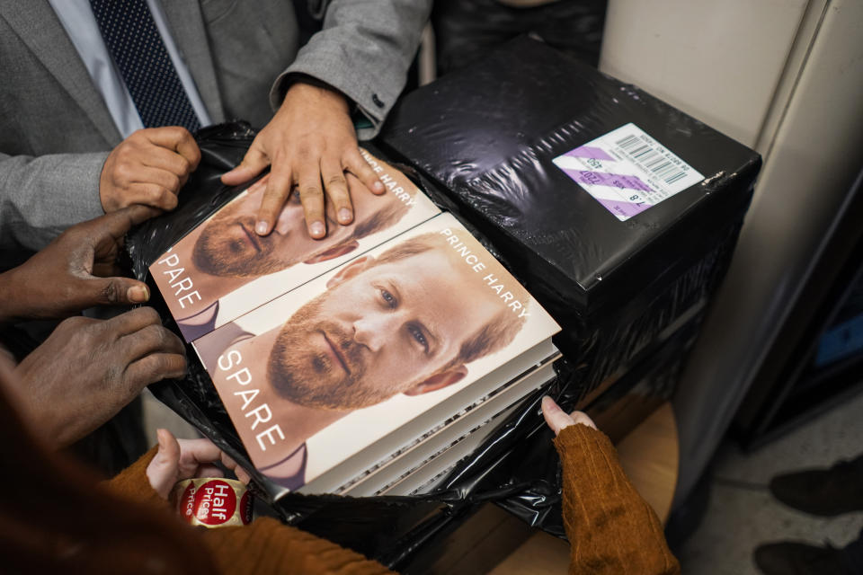 Copies of the new book by Prince Harry called "Spare" are held by a member of staff of a book store during a midnight opening in London, Tuesday, Jan. 10, 2023. Prince Harry's memoir “Spare” arrives in bookstores on Tuesday, providing a varied portrait of the Duke of Sussex and the royal family. (AP Photo/Alberto Pezzali)