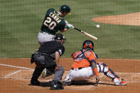 Oakland Athletics' Mark Canha (20) hits a solo home run off in front of Houston Astros catcher Martin Maldonado and umpire Jerry Meals (41) during the second inning of Game 3 of a baseball American League Division Series in Los Angeles, Wednesday, Oct. 7, 2020. (AP Photo/Ashley Landis)