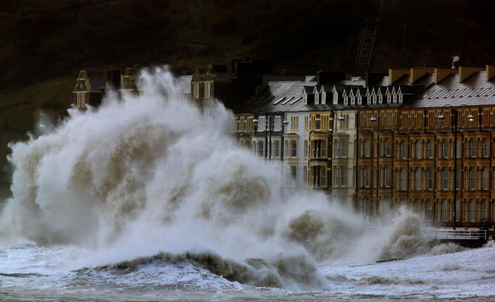 Waves crash against the Aberystwyth coastline, in Wales, as strong winds and high tides continue to blow in from the west, Monday Jan. 6, 2014. Residents along Britain's coasts are braced for more flooding as strong winds, rain and high tides lash the country. At least three people have died in a wave of stormy weather that has battered Britain since last week, including a man killed when his mobility scooter fell into a river in Oxford, southern England. (AP Photo/PA, Dave Thompson) UNITED KINGDOM OUT