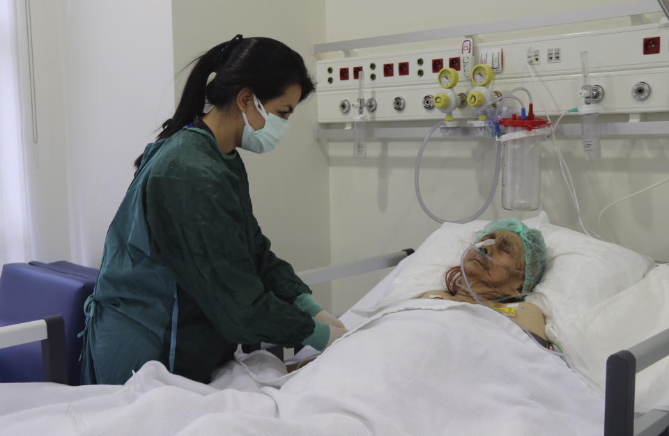 A nurse monitors Ayse Karatay at the City Hospital in Eskisehir, western Turkey, Saturday, Sept. 4, 2021. Karatay, a 116-year-old Turkish woman has survived COVID-19, her son said Saturday, making her one of the oldest patients to beat the disease. Ayse Karatay spent three weeks in intensive care and has now been moved to a normal ward, her son Ibrahim Karatay told the Demiroren news agency. (IHA via AP)